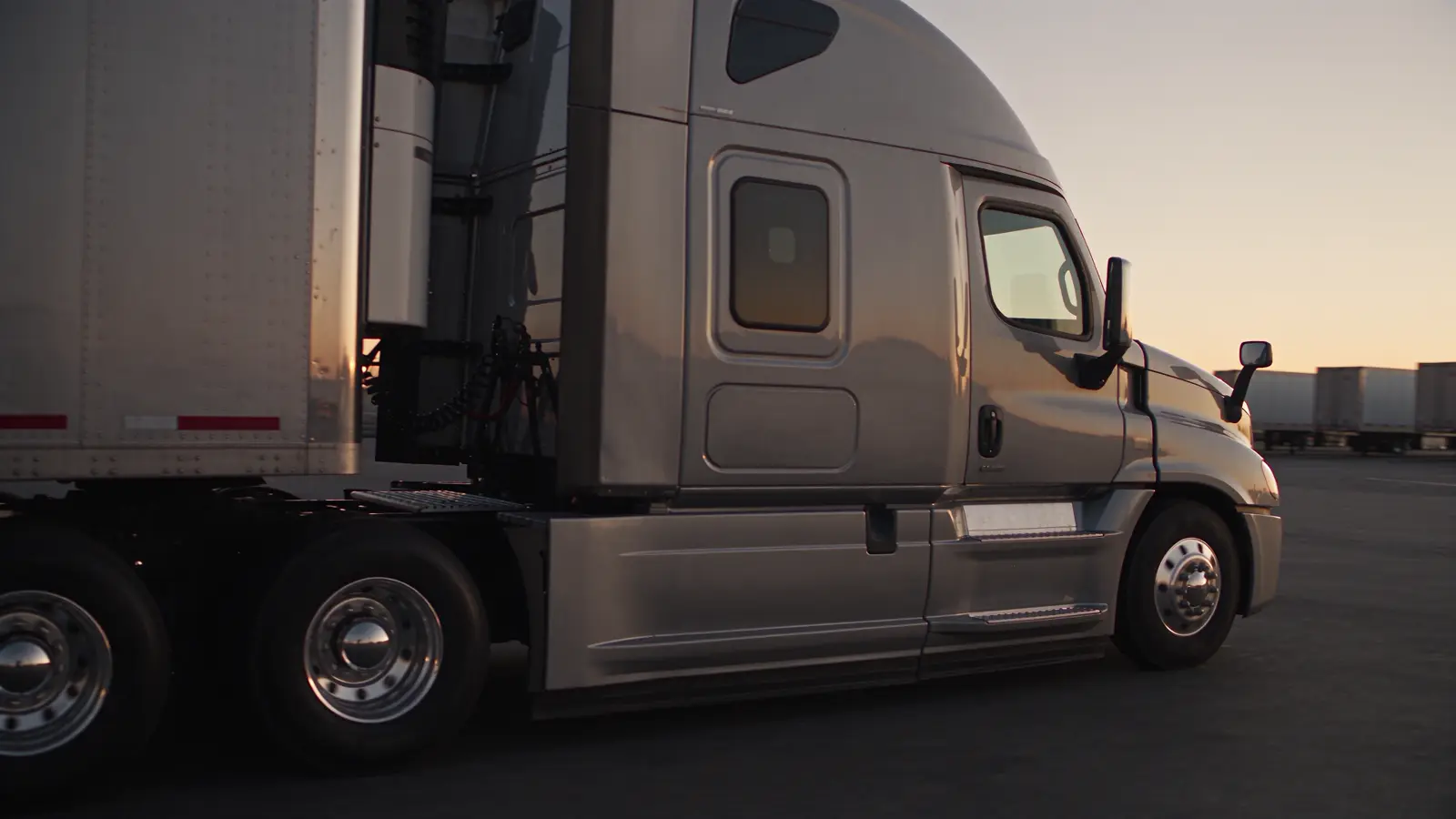 A graphite dry van semi truck at a freight terminal